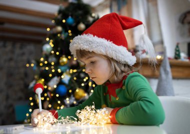 Çocuk Noel çelenklerinin arkasında bir masaya oturur ve Noel Baba 'ya bir mektup yazar. Kırmızı şapkalı 7 yaşındaki bir çocuk hediyelerin hayalini kuruyor. Hediye dilek listesi