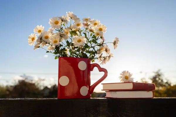vase with white chrysanthemum flowers, books. Good morning. concept of reading, romantic mood, education, wisdom and knowledge. Digital detox. Book Day. selective focus. Valentine\'s Day