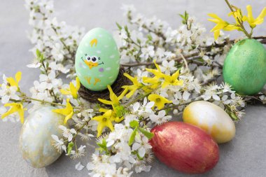 Bahar çiçekleri açan kiraz dallarıyla renkli Paskalya yumurtaları. Şefkat, sakinlik, uyum. Çiçek açan bahar. Paskalya konsepti