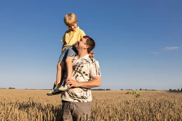 unity of daddy and son. The concept of a friendly family, a joyful childhood and fatherhood. the man put the child on his shoulder. Having fun, positive thinking. Father\'s Day