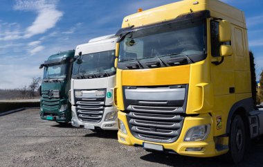 Güneşli bir günde bir otoparkta arka arkaya park etmiş üç renkli taksi. - Evet. Ticari araçlar, ticari kargo taşımacılığı için araçların reklamları. Kiralama için sanayi makineleri