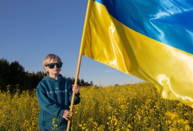 Kazaklı çocuk. Ben Ukraynalıyım. Sarı ve mavi gözlüklü, kolza tohumu tarlasında mavi ve sarı renkli gözlüklü. Bir çocuk vatanına barış diliyor. Bağımsızlığın ulusal sembolü