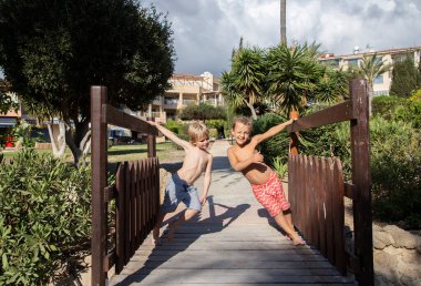 İki çocuk, 5-6 yaşlarında şortsuz, güneşli bir günde güneşleniyorlar ve birbirleriyle konuşuyorlar. İyi bir ruh hali, yaz tatili, arkadaşlık, ilginç bir çocukluk. Sıcak hava