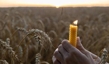 Gün batımında buğday tarlasında kadınların elinde mum yakmak. Ukrayna 'daki Holodomor trajedisinin anısına konsept fotoğraf. Ukrayna yanıyor, savaşı durdurun.