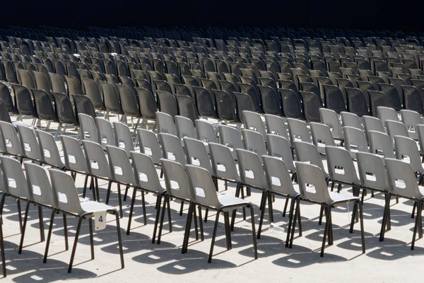 屋外コンサートや野外イベントのための列と列で多くの黒と白のプラスチック製の椅子が設定されました — ストック写真