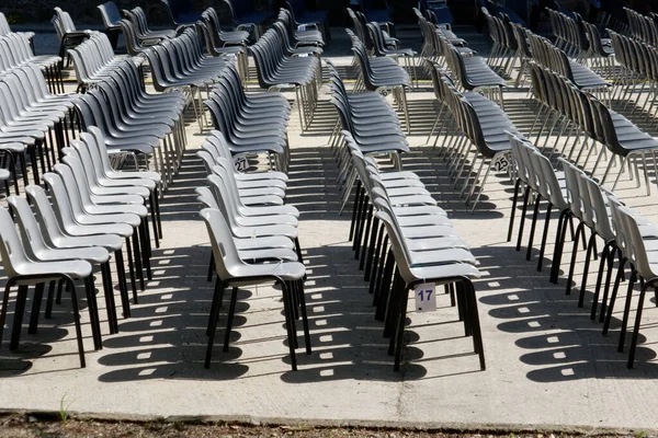 许多黑白相间的塑料椅子设置在室外音乐会或露天活动的排座位和柱子上 空座位 — 图库照片