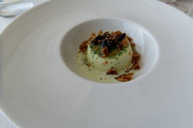 Karamel ve taggiasca zeytinleriyle süslenmiş pesto sosuyla aromalı panna cotta adı verilen lezzetli İtalyan tatlıları.