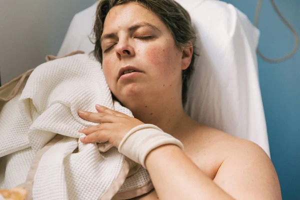 Woman trying to sleep with a blanket in hospital room. Health care concept.