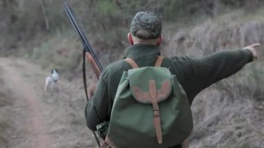 Avcı adam doğada avlanırken köpeklerine talimat veriyor. Av sezonu konsepti.