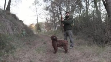 Avcı adam dışarıda köpeğiyle avlanırken avını arıyor. Av sezonu konsepti.