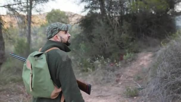狩猟中に犬と自然を歩く銃を持つハンター男 狩猟シーズンのコンセプト — ストック動画