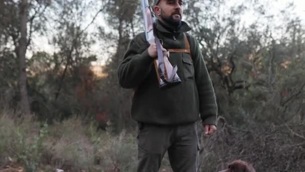 ハンターの男が銃を持って自然を見ながら立っている 狩猟シーズンのコンセプト — ストック動画