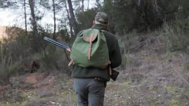 バックパック付きのハンターマンは 自然の中を歩いている間にショットガンを持っています 狩猟シーズンのコンセプト — ストック動画