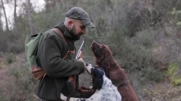 Homem Caçador Com Espingarda Acariciando Seus Cães Enquanto Caçam Juntos — Vídeo de Stock