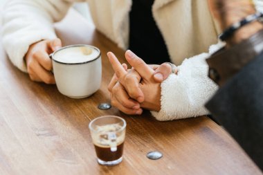 Bir çift, kahve içerken el ele tutuşuyor, sohbet ediyor ve şehirde eğlenceli bir öğleden sonra geçiriyor..
