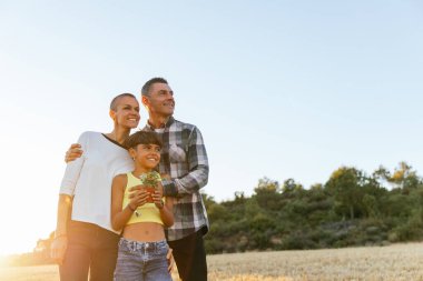 Mutlu aile gün batımında kırsalda boş bir aktivitenin keyfini çıkarıyor. Sevgi ve olumlu duygularla birleşiyor..