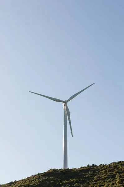 windmill perched atop a hill, harnessing the natural energy of the wind. The image showcases the harmonious blend of technology and nature, as the windmill generates clean and sustainable energy.