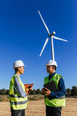 Yenilenebilir enerji üzerinde çalışan iki mühendis. Gündüzleri kırsal bir rüzgar türbini tarlasında çalışıyorum..
