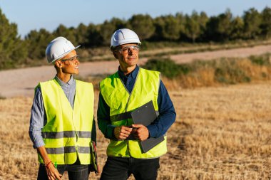 Güneşli bir sabahta rüzgâr çiftliğinde çalışan bir bakım mühendisi ekibi, çevre dostu enerji üretiminin keyfini çıkarıyorlar..