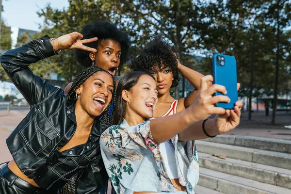 Birlikte komik bir selfie çekerken dört farklı arkadaşın başarısının yan görüntüsü.