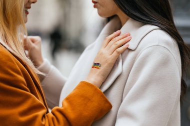 Elinde lgbt gökkuşağı dövmesi olan bir kadın kız arkadaşının yanında dikilirken geçici bir dövme yaptırmış. LGBT kavramı.