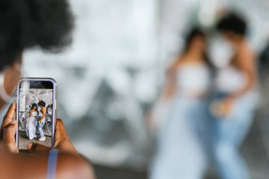 Kadınlar ve transseksüel kadın açık havada video dansı yaparken mobil ekrana odaklan.