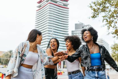 Çeşitli kadın grupları modern bir şehirde kahkahalarla yakalanır. Şehir içinde kaygısız bir keyif anı..