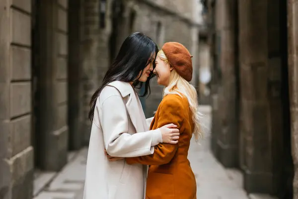 stock image Tender moment between two young women embracing in the narrow streets of barcelonas gothic quarter