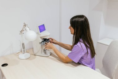 Optometrist, modern bir klinikte göz muayenesi için bir lens hazırlıyor.