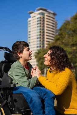 Engelli anne ve oğlu açık havada, zorlukların üstesinden gelmek için sevgi, ilgi ve desteğin önemini vurgulayan yürek ısıtan bir anı paylaşıyorlar.