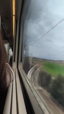 Trenin camından bakan, yüksek hızda seyahat ederken bulanık çöl manzarasını gören, manzaralı yolculuk perspektifini yakalayan yolcular.