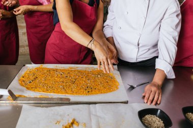 Profesyonel aşçı, aşçılık kursunda öğrencilere tohum ve baharat serpmeyi öğretiyor.