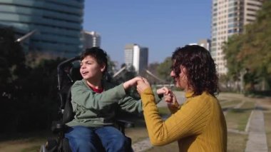Sevgi dolu bir anne, dokuz yaşındaki oğluyla neşeyle dans ediyor. Beyin felci geçirmiş, güneşli şehir parkında iç açıcı bir bağ anı yaşıyor.