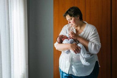 Bir aylık oğlunu evde besleyen annesi sevgi ve bağlarla dolu sıcak ve besleyici bir ortam yaratıyor.