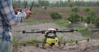 Çiftçi İHA kontrolörü ya da İHA vericisi kullanmaya başlar kırsal alanda kırsal alanda tarımsal püskürtücü drone için uzaktan kumanda