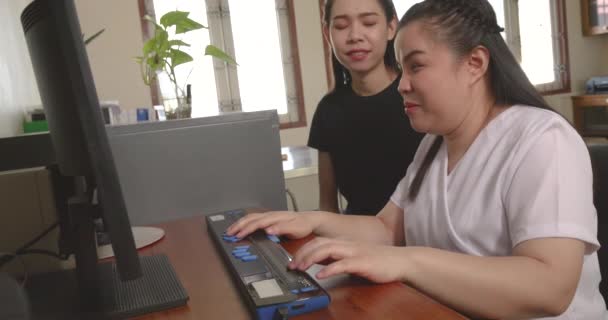 オフィスで働く幸せなアジアの女性たち 点字ディスプレイ補助機器を使って 視覚障害者を含む職場の同僚たち 仕事の概念における障害者のインクルージョン — ストック動画