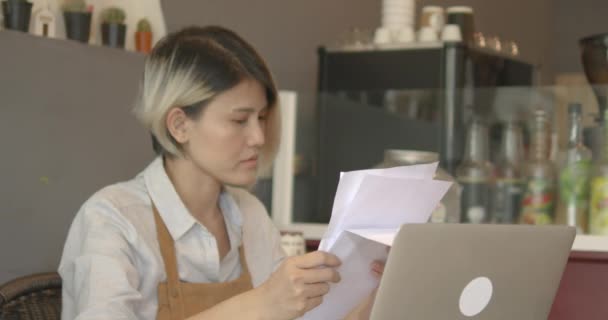 Азіатська Жінка Фартусі Власник Малого Бізнесу Турбується Про Оплату Рахунків — стокове відео