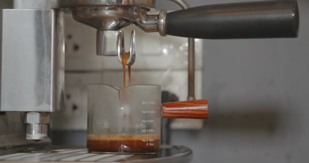 Χύνοντας Ροή Καφέ Από Μηχανή Καφέ Espresso Γυάλινο Κύπελλο Μέτρησης — Αρχείο Βίντεο