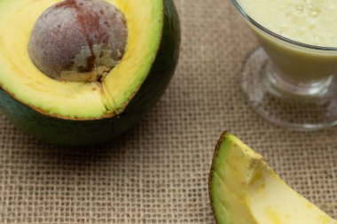 Ahşap arka planda avokado smoothie ve meyve