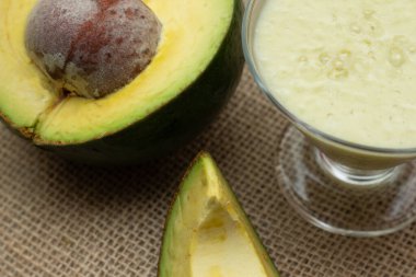 Ahşap arka planda avokado smoothie ve meyve