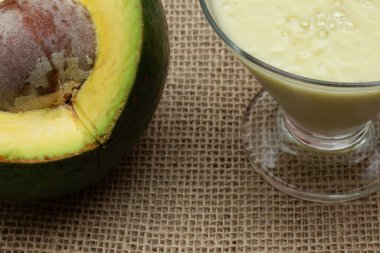 Ahşap arka planda avokado smoothie ve meyve