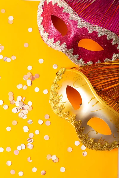 two colored masks on an orange background with ornaments