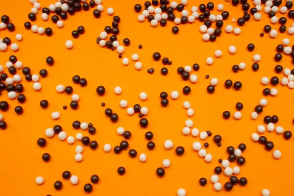stock image white and black chocolate balls on an orange background