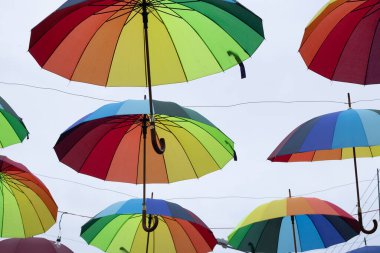 Bulutlu bir günde asılı renkli şemsiyeler