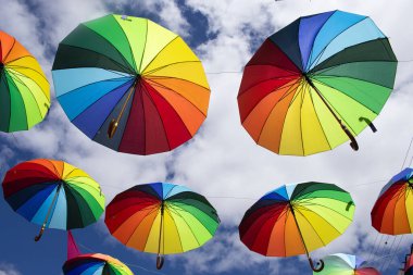 Güneşli bir günde sarkan renkli şemsiyeler