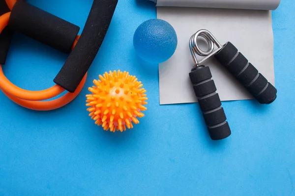 Mini top, elastik bant ve mavi arka planda diğer spor aletleri.