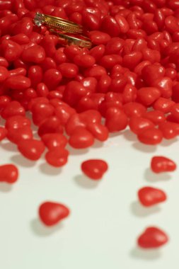 İki alyans ve beyaz masada birkaç küçük kalp.