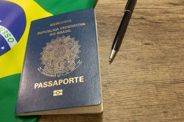 LAURO DE FREITAS, BRAZİL - 26 Nisan 2024 Brezilya bayrağının yanındaki Brezilya pasaportu