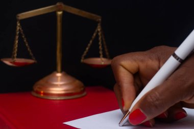 hand writing with scales of justice in an institutional environment clipart