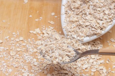 Bir kase dolusu yulaf ve yanında kaşık.